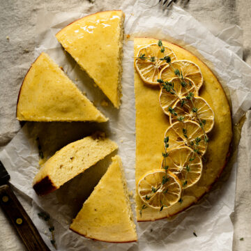 Lemon cake on parchment paper with have cut into slices